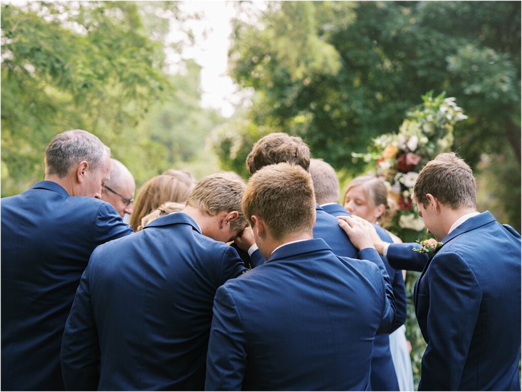 Documentary photo of family praying over a wedding couple