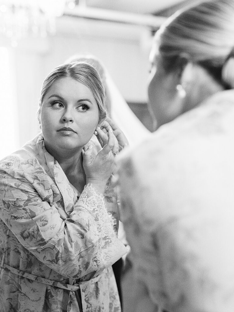 Bride putting on earrings