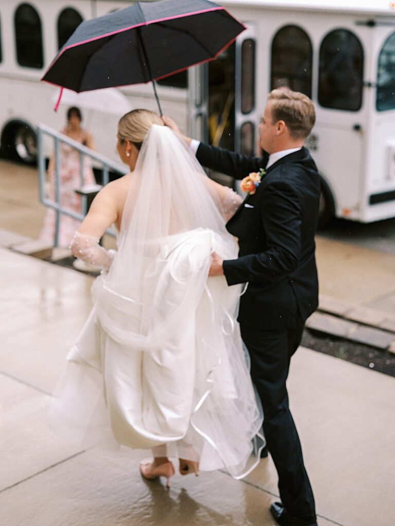 Bride and Groom in the rain at St. Ambrose Cathedral in Des Moines